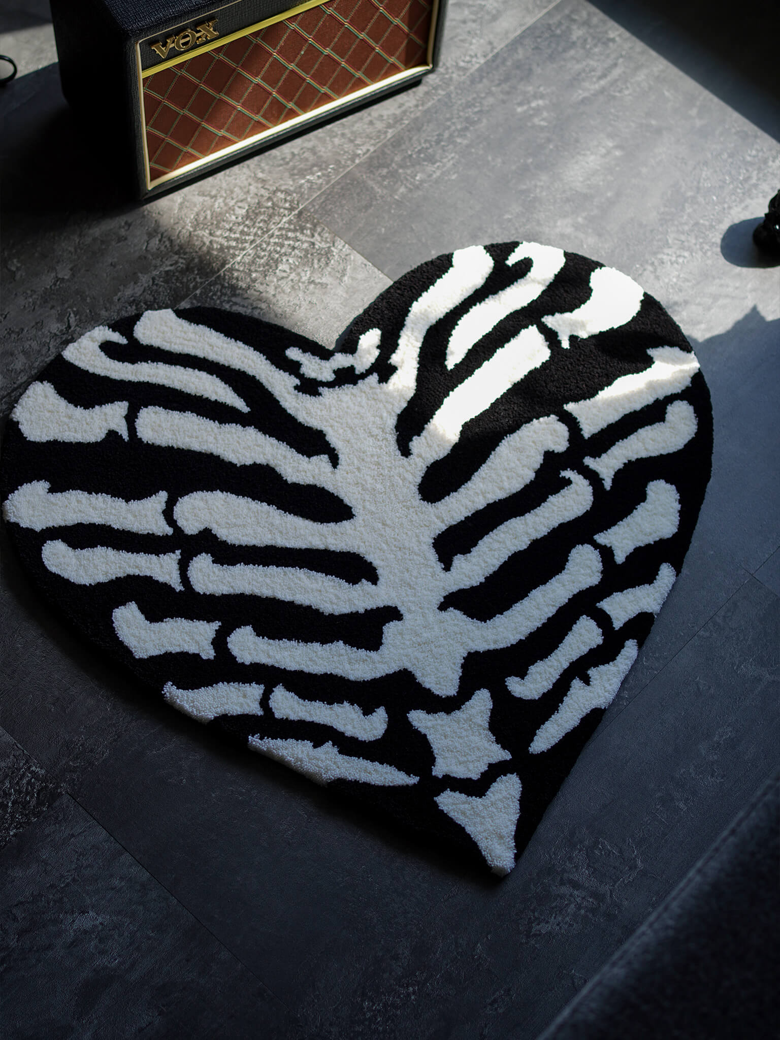 The Ribcage Heart Rug styled in a dark alternative room, perfect for underground interior design.