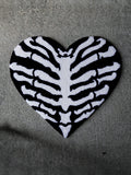 The Ribcage Heart Rug by Void Rugs. A bold hand-tufted rug featuring a ribcage inside a heart silhouette.