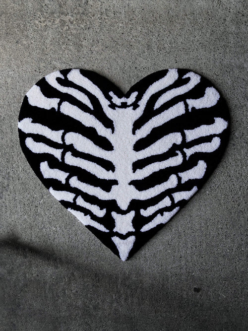 The Ribcage Heart Rug by Void Rugs. A bold hand-tufted rug featuring a ribcage inside a heart silhouette.