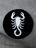 The Scorpion Circle Rug. A bold, stark-white scorpion icon against a solid black background.