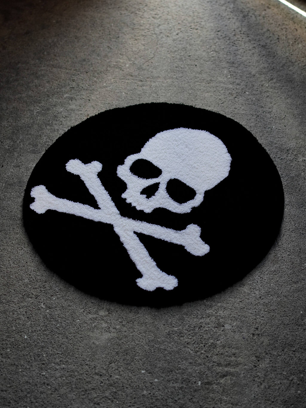 Side angle of the Skull and Crossbones rug, displaying the solid blackwork aesthetic and handmade quality.