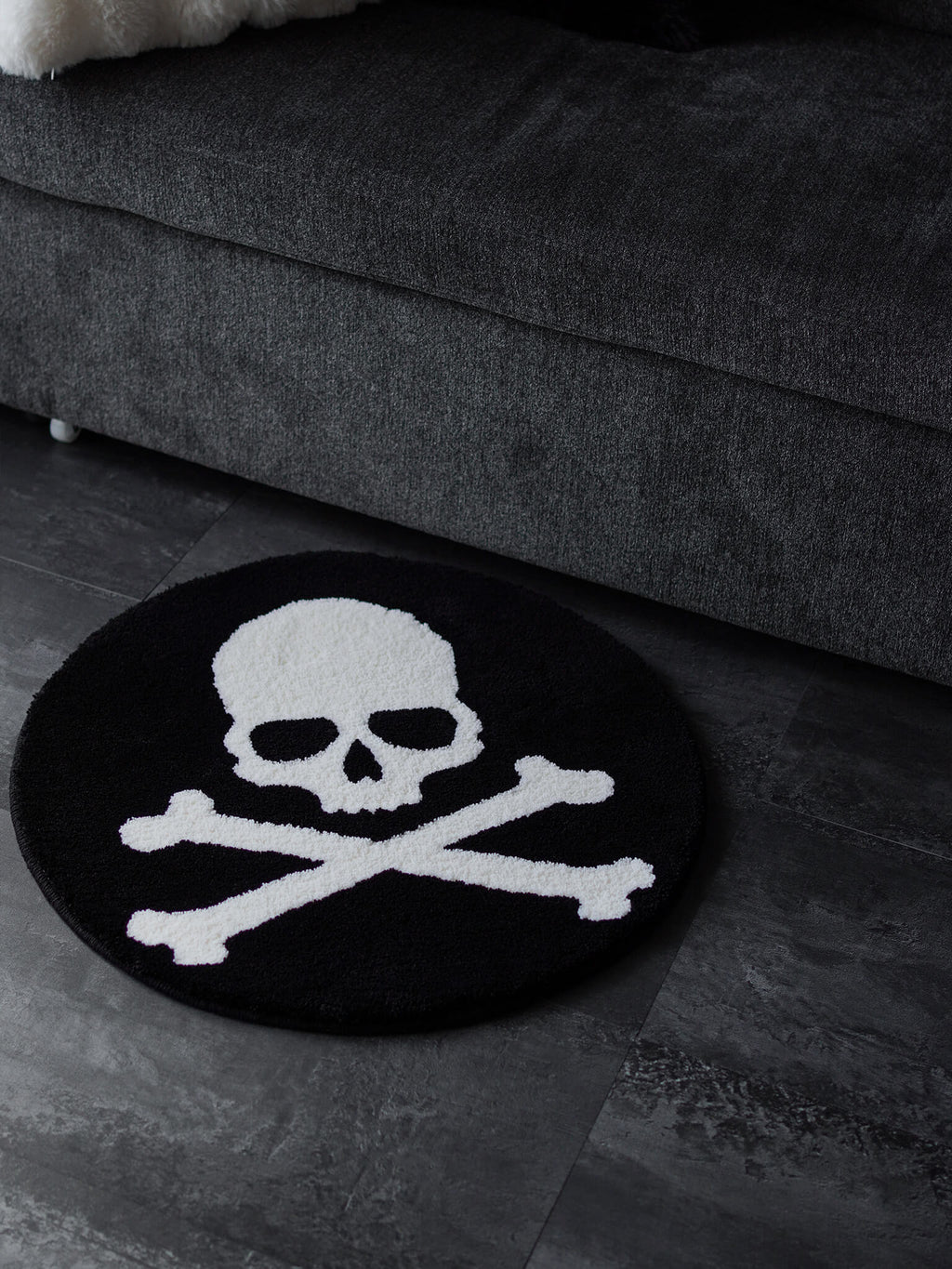 Skull and Crossbones circle rug placed on a floor, adding a dark subculture vibe to the living space.