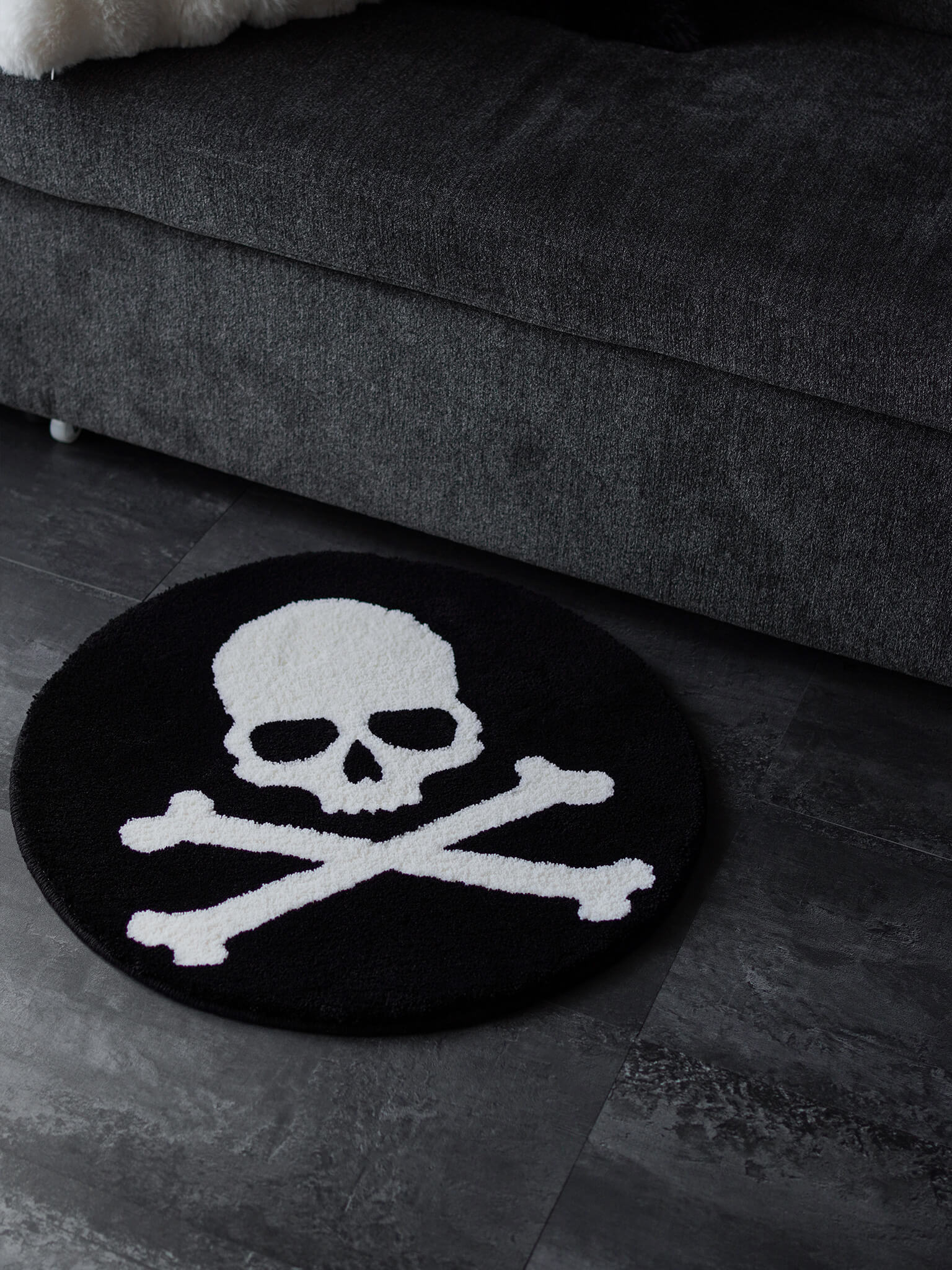 Skull and Crossbones circle rug placed on a floor, adding a dark subculture vibe to the living space.