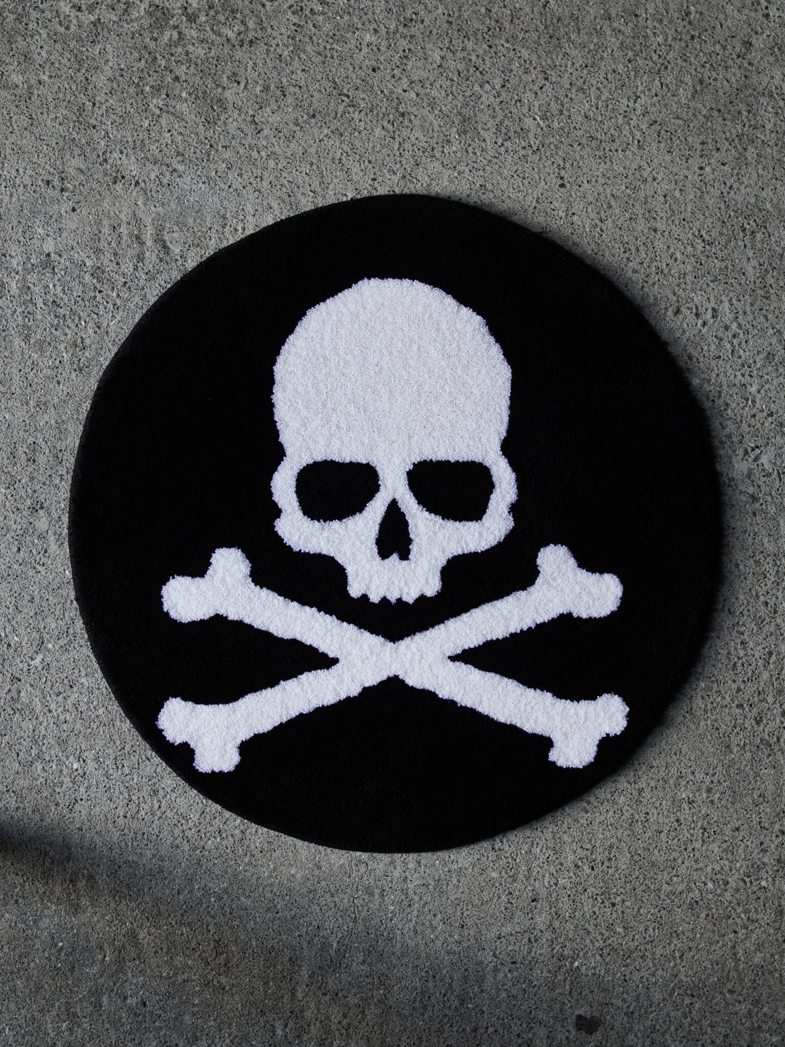 The Skull and Crossbones Circle Rug. A clean, classic underground tattoo design tufted in heavy black and white.